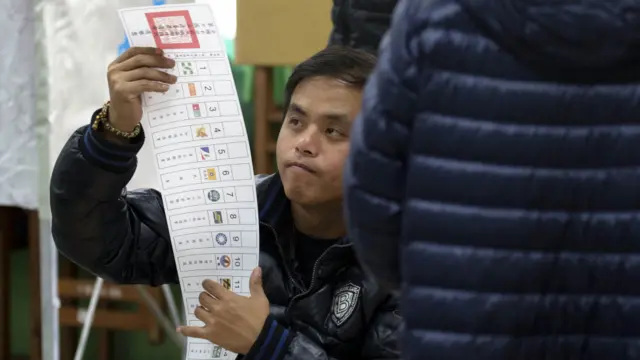 台北某投票站內一名選民在閱讀選票（16/1/2016）