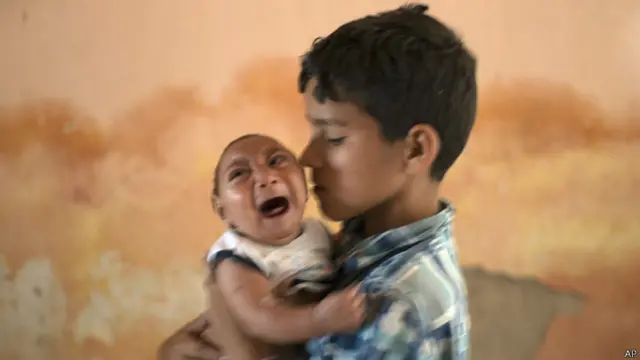 Elison, de dos meses, en brazos de su hermano José Wesley, de 10 años, en su casa de Poco Fundo, Pernambuco