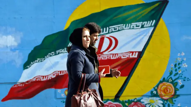 Пара на фоне граффити иранского флага