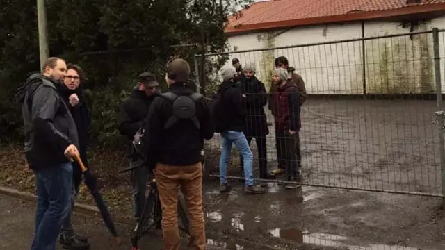 我们站在外面向里面看，里面的人透过铁门的栅栏向外看