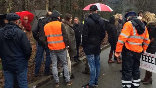 难民营门口人还是越聚越多，警车在周围不停巡逻