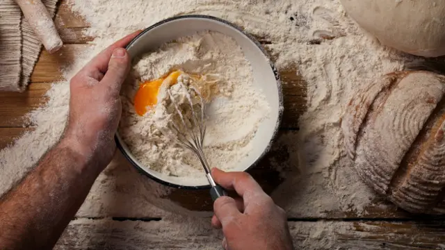 Мужчина печет хлеб