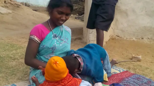 दिहाड़ी मज़दूर मंगरू मुंडा की पत्नी विनी मुंडा अपने बच्चों के साथ.