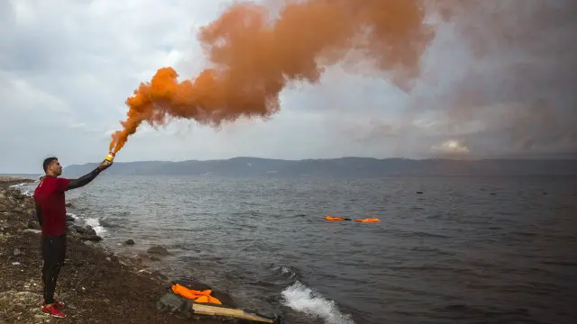 Un joven con humo anaranjado