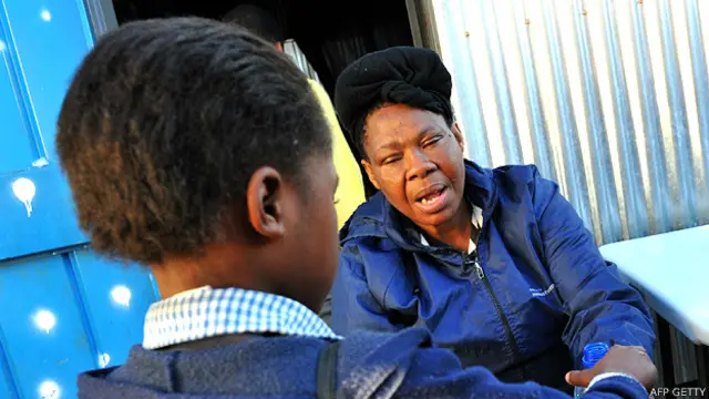 Niña que perdió sus padres por el SIDA junto a Portia Mongake, que alimenta a 100 niños huerfanos por la epidemiaa 