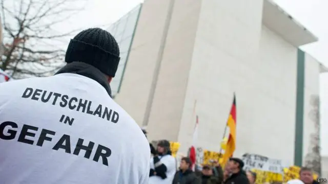 在德國總理府前抗議強姦案的抗議者的T恤上寫著「德國處於危險中」的字樣