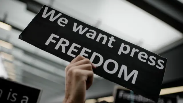 寫著「我們要新聞自由」的牌子