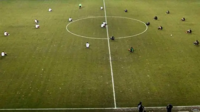 Para pemain dan pelatih dari klub AEL Larissa dan Acharnaikos duduk di lapangan selama sekitar dua menit setelah wasit meniup laga dimulai pada Jumat (29/01).