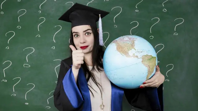 Una graduanda sosteniendo un globo terráqueo