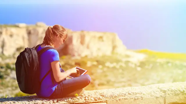 Una joven con una tableta en un lugar abierto