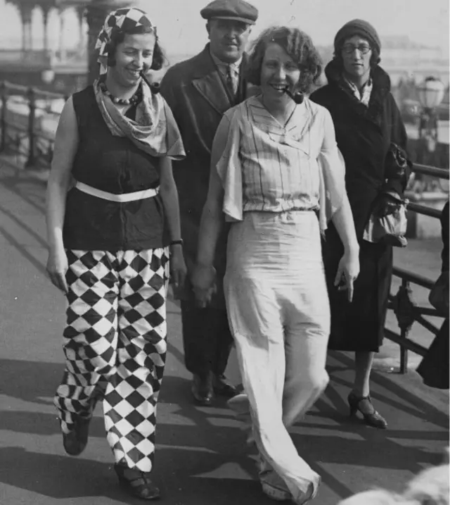 A couple of young women strolling along the beach