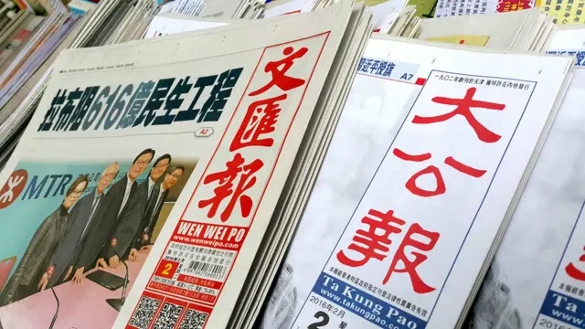 香港中环某报摊上发售的《文汇报》（左）与《大公报》（右）（BBC中文网图片2/2/2016）