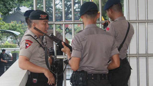 Aparat bersenjata lengkap berjaga di luar ruang pengadilan.