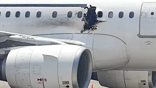 मोगादिशू के अदन अब्दुल अंतरराष्ट्रीय हवाई अड्डे पर खड़ा विमान.