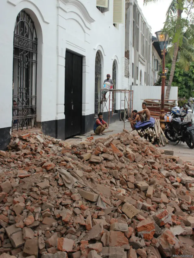 Sejumlah tukang bangunan tengah beristirahat dalam proyek renovasi bangunan tua bersejarah di kawasan kota tua Jakarta.