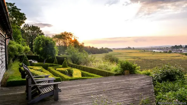 Amanecer en una plataforma de madera que da campos abiertos
