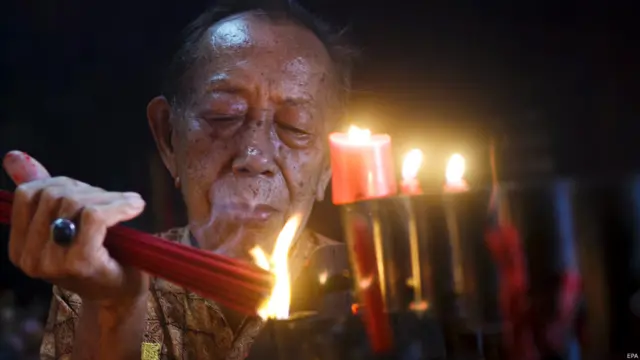  चीनी नव वर्ष के मौक़े पर इंडोनेशिया में बाली के कुता मंदिर में एक इंडोनेशियाई अगरबत्ती जलाकर प्रार्थना करते हुए.