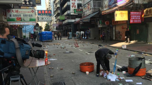 衝突過後，凌亂的旺角，商家在街邊點燃的蠟燭、攝像記者以及拾垃圾的老人。