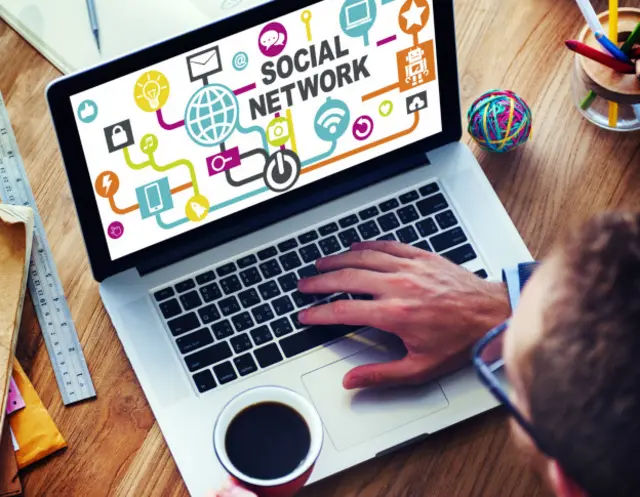 Una persona mira una laptop con el mensaje "social networking"