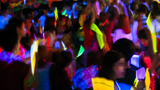 Люди со светящимися палочками