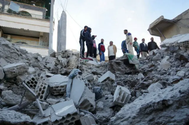 Мирные жители на развалинах дома