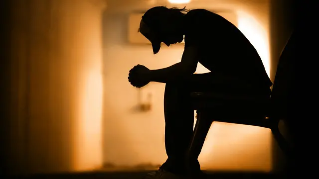 Un hombre sentado cabizbajo