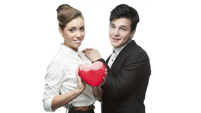 Una pareja sosteniendo un corazón de plástico