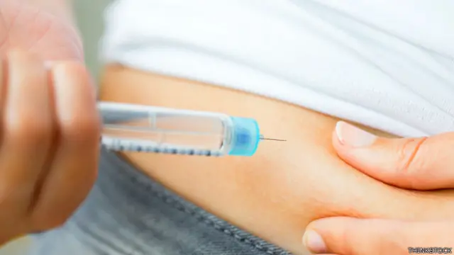 Mujer inyectándose insulina