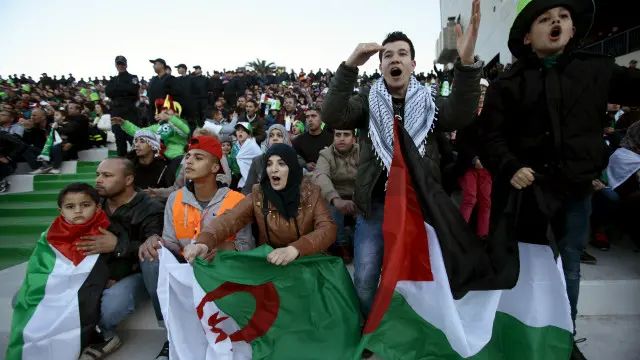 عائلة فلسطينية تشاهد المباراة وهي تحمل العلمين الجزائري والفلسطيني