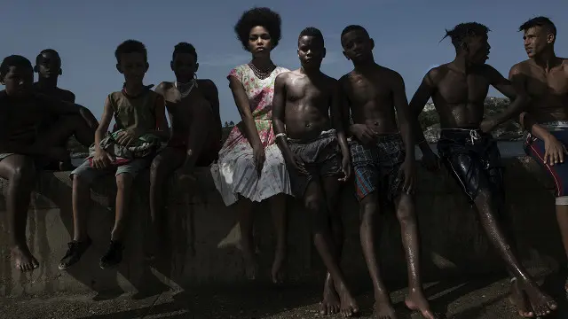 Una mujer posa junto a jóvenes cubanos sin camiseta