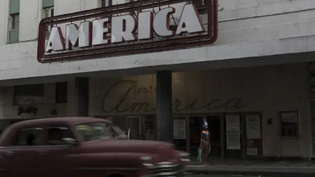 Mujer vestida de vedette frente al teatro America