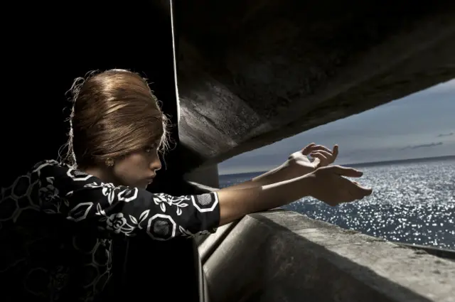 Una mujer reposa en una silla dentro de una de las típicas casas antiguas de La Habana