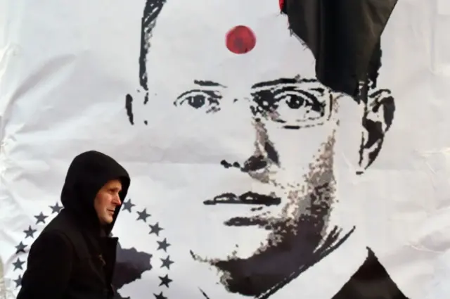 Житель Киева на фоне баннера с портретом Арсения Яценюка