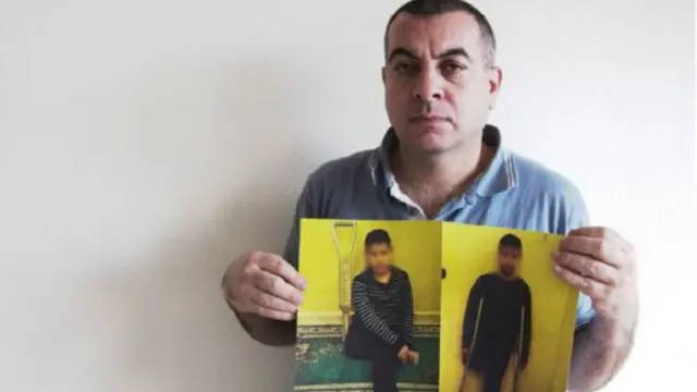 محمد ومعه صور لنجله المعاق وهو واحد من عدة آلاف لحقت بهم إصابات جراء الصراع في سوريا