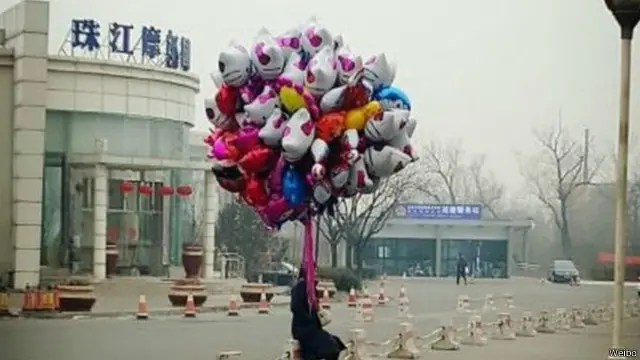 Seorang penjual balon sendirian di tengah pusat perbelanjaan retail di Tahun Baru Cina yang 'dingin'.