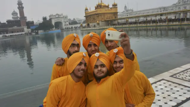 Amritsar'daki Altın Tapınak önünde selfie geçen Sih gençler.