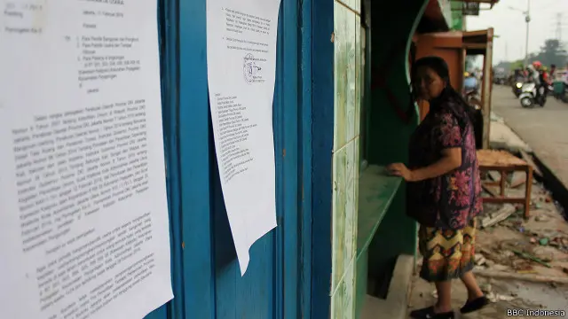 Di jalan besar, Juwita, terus memandangi bekas toko miliknya yang bercat hijau. 