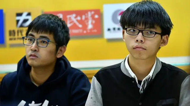 香港学民思潮召集人黄之锋（右）和前秘书长周永康（左）等三人被控“煽动非法集会”。