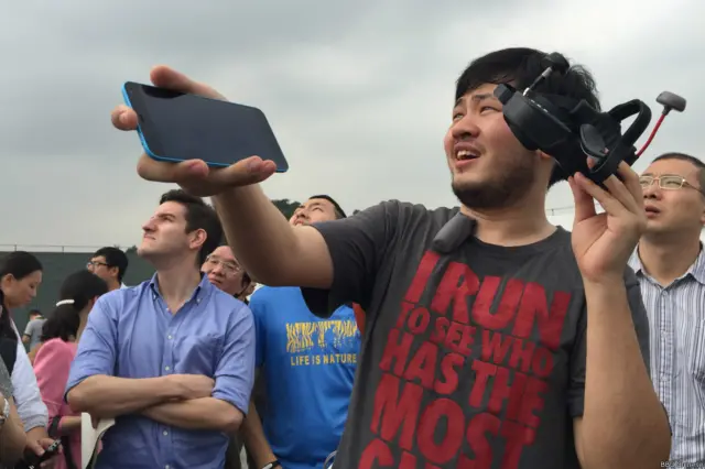 熊逸放向記者展示手機操作無人機。