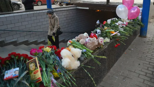 Қизчанинг бошини кўтариб олган ўзбекистонлик аёл ушланган метро бекати ёнига москваликлар гуллар қўйишмоқда.