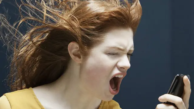 Девушка злобно кричит на свой телефон