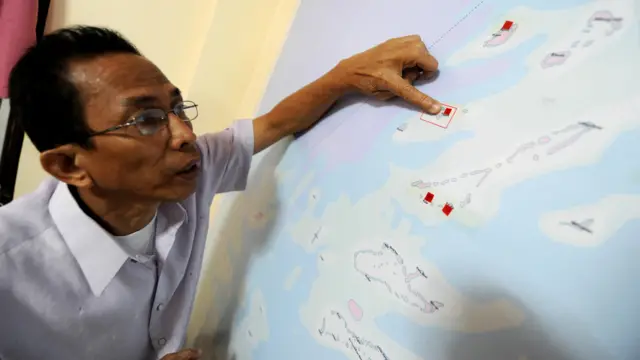 卡拉延市市长比托—奥农在巴拉望省公主港的办公室内阅读中业岛地图（资料图片）