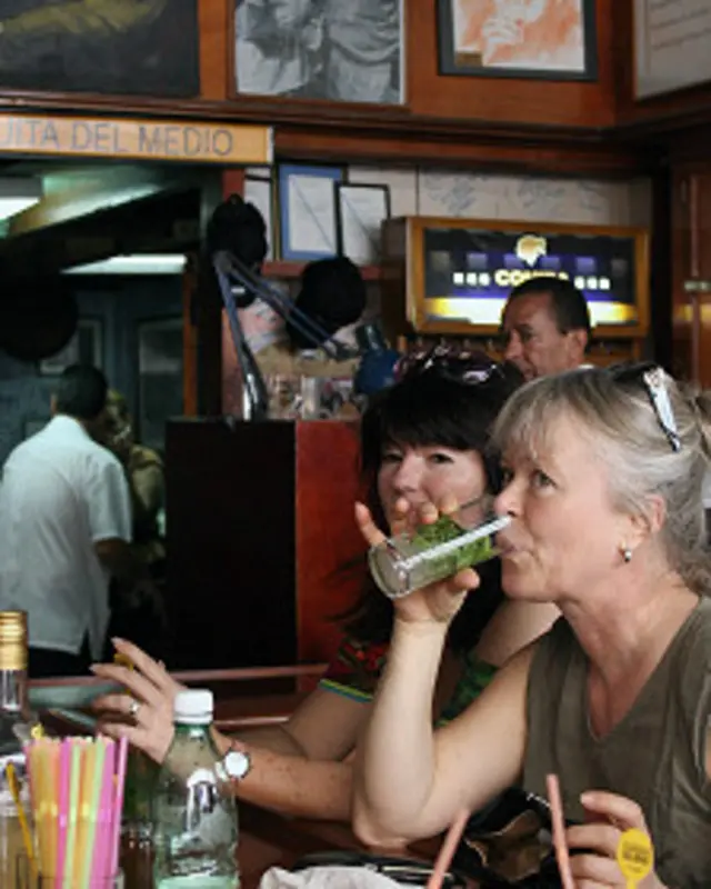Una mujer bebe un mojito en La Bodeguita del medio, en La Habana