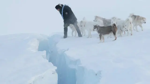 أعضاء دورية سيريوس المتزلجة من ذوات الأربع ومعهم الحارس أمام صدع جليدي