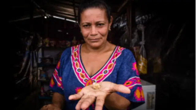 Una mujer con oro en las manos.
