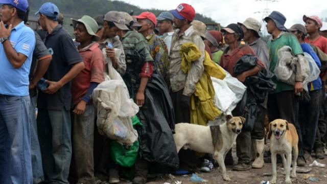 Personas que viven de recoger basura hacen cola para recibir alimentos de una ONG en Honduras