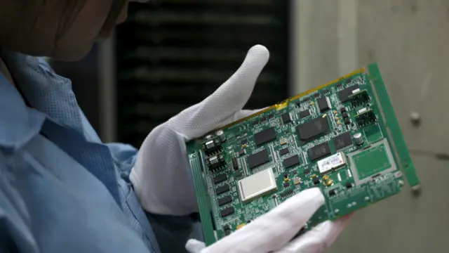 中兴通讯深圳厂区内一名女工查看一块电脑底板（资料图片）