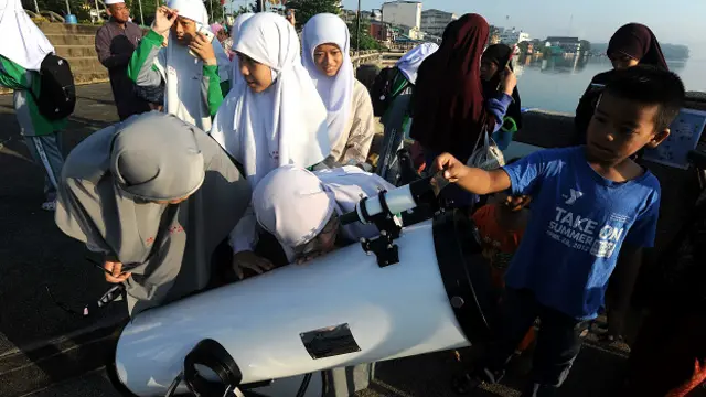 थाईलैंड में दूरबीन से सूर्यग्रहण देखते स्कूली बच्चे.