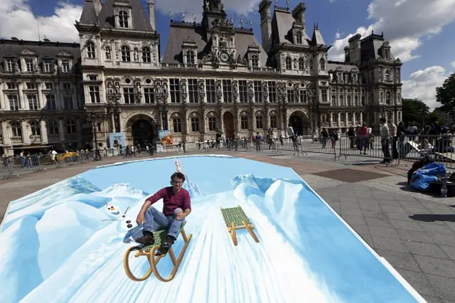 2015年5月23日，作为欧洲迪士尼活动的一部分，德国街头画家埃德加·穆勒(Edgar Mueller)在巴黎市政厅前绘制错觉画。(图片来源：Getty)