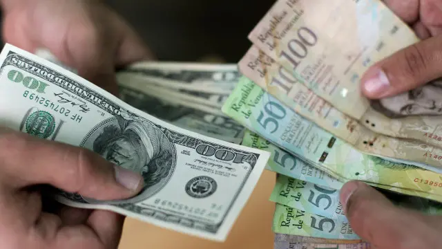 Billetes de dólares y de bolívares